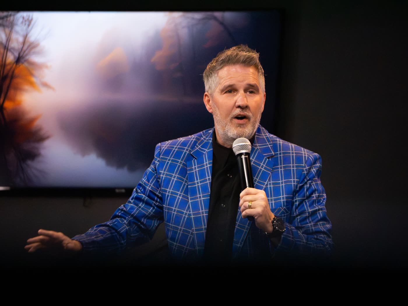 A minister speaking into a microphone during a Sunday service